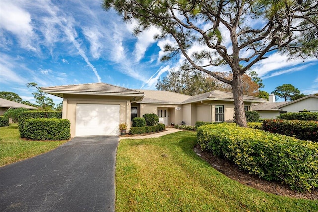 ranch-style home featuring a garage and a front lawn