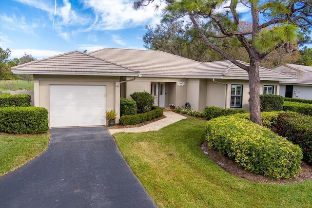 ranch-style house with a garage and a front lawn