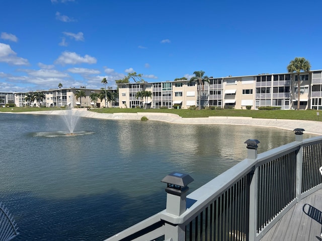 dock area with a lawn and a water view