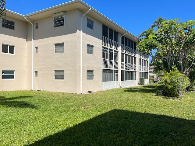 back of property featuring a lawn