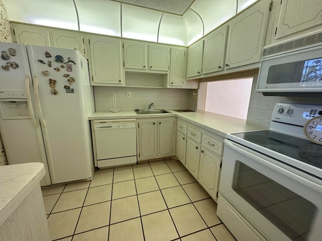 kitchen with white appliances, sink, backsplash, and light tile flooring