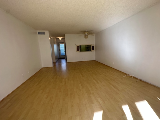 unfurnished living room with a textured ceiling, ceiling fan, and light hardwood / wood-style flooring