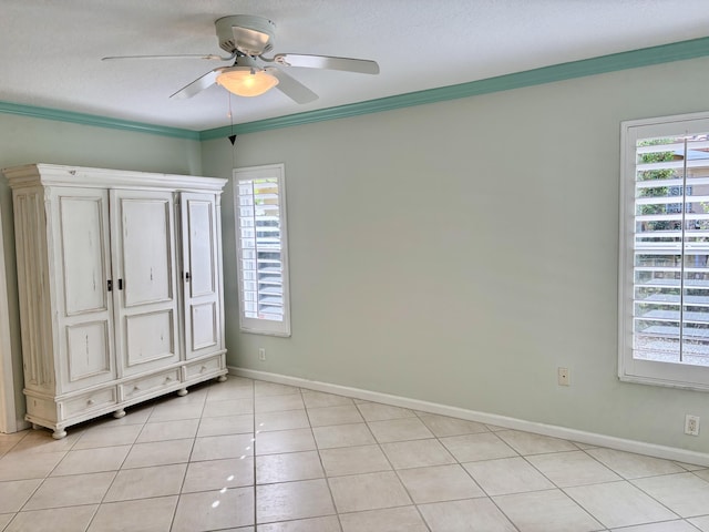 unfurnished bedroom with ceiling fan, light tile patterned flooring, ornamental molding, and a textured ceiling