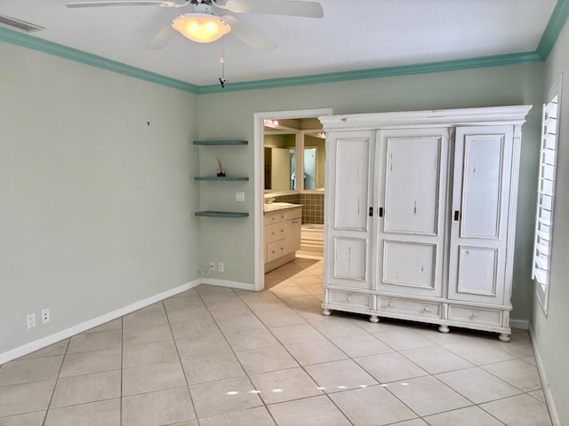 unfurnished bedroom featuring ceiling fan, light tile patterned flooring, ensuite bathroom, and crown molding