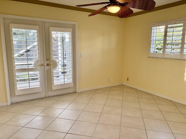 spare room with a wealth of natural light, french doors, light tile patterned floors, and ceiling fan