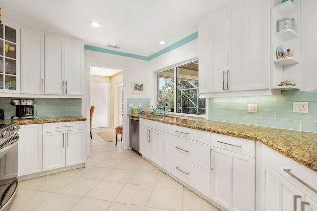 kitchen featuring white cabinets, sink, tasteful backsplash, light stone counters, and stainless steel appliances