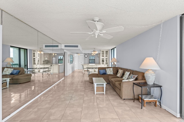 living room with light tile floors, a textured ceiling, and ceiling fan