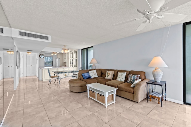 tiled living room featuring a textured ceiling and ceiling fan