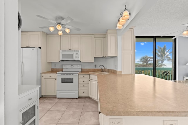 kitchen featuring ceiling fan, white appliances, sink, light tile floors, and cream cabinetry