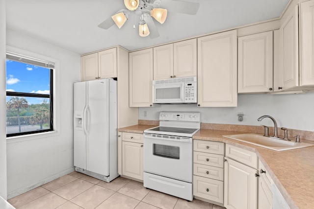 kitchen featuring ceiling fan, white appliances, sink, light tile floors, and cream cabinetry