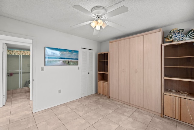 interior space with light tile floors, a textured ceiling, and ceiling fan