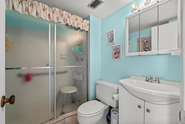 bathroom featuring toilet, tile floors, a shower with shower door, and large vanity