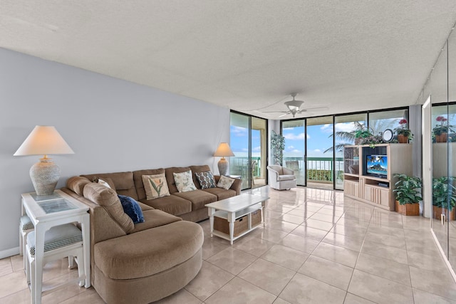 living room featuring light tile floors, expansive windows, a textured ceiling, and ceiling fan