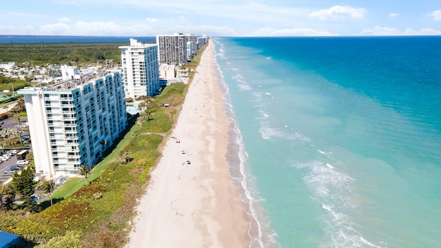 aerial view with a water view and a beach view