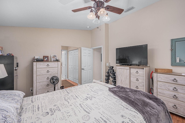 bedroom with ceiling fan, wood-type flooring, and vaulted ceiling