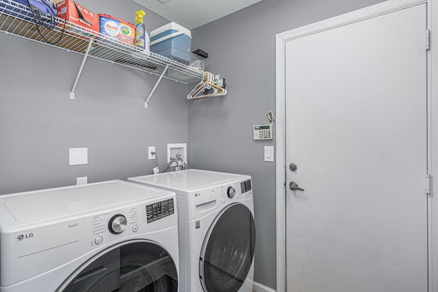 laundry area featuring a textured ceiling and washing machine and clothes dryer