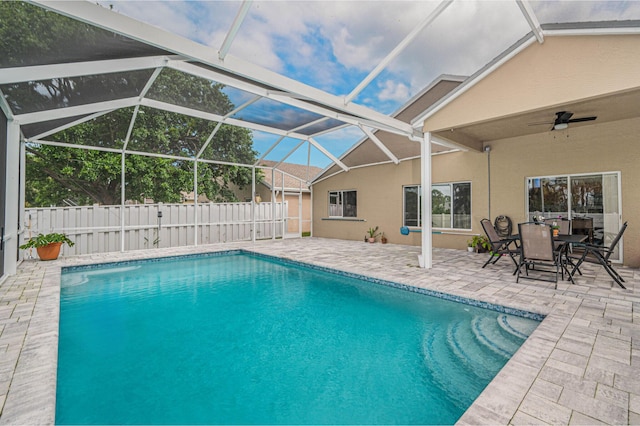 view of pool featuring glass enclosure, ceiling fan, and a patio area