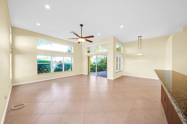 unfurnished living room featuring light tile floors and ceiling fan