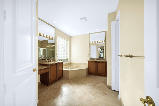 bathroom featuring tile floors, a bathing tub, and vanity