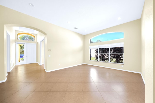 tiled spare room with lofted ceiling