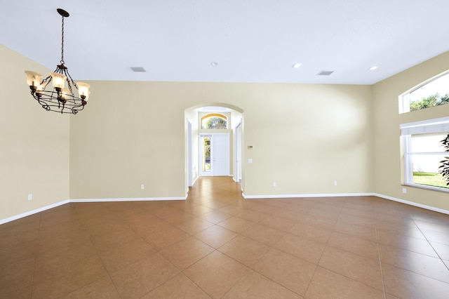 tiled empty room with a chandelier