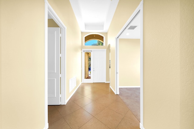 hall with light carpet, a tray ceiling, and french doors