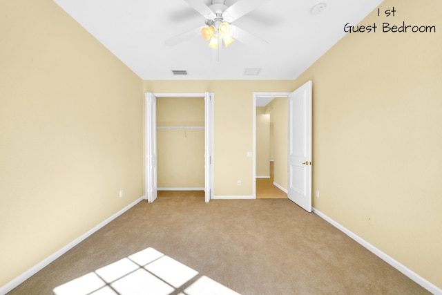 unfurnished bedroom featuring light carpet, a closet, and ceiling fan