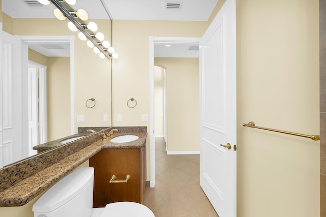 bathroom with tile flooring, vanity with extensive cabinet space, and toilet