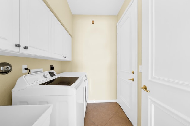 clothes washing area with washing machine and dryer, cabinets, hookup for an electric dryer, light tile floors, and washer hookup