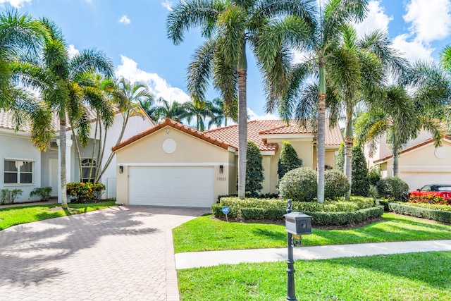 mediterranean / spanish-style home featuring a front lawn and a garage