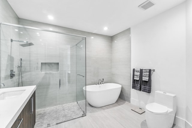 bathroom featuring tile walls, walk in shower, toilet, tile floors, and vanity