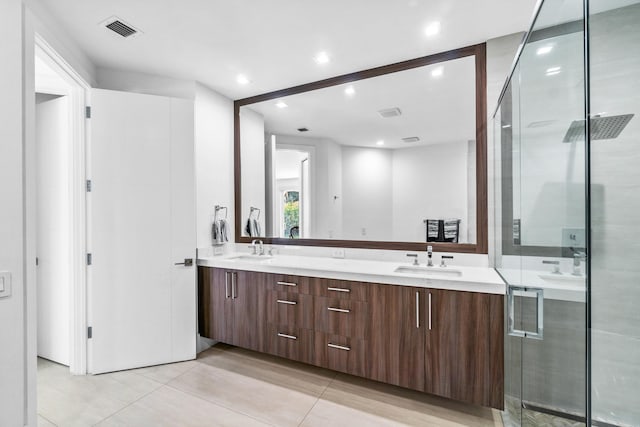 bathroom with double vanity, tile floors, and a shower with shower door