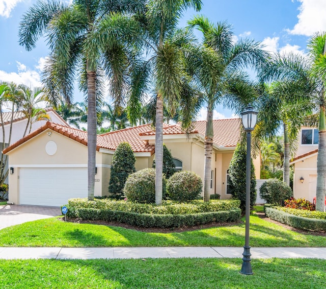 mediterranean / spanish-style house with a front yard and a garage