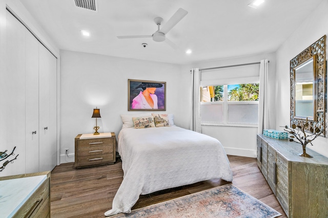 bedroom with a closet, ceiling fan, and dark hardwood / wood-style floors