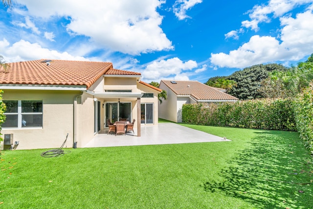 rear view of property with a yard and a patio