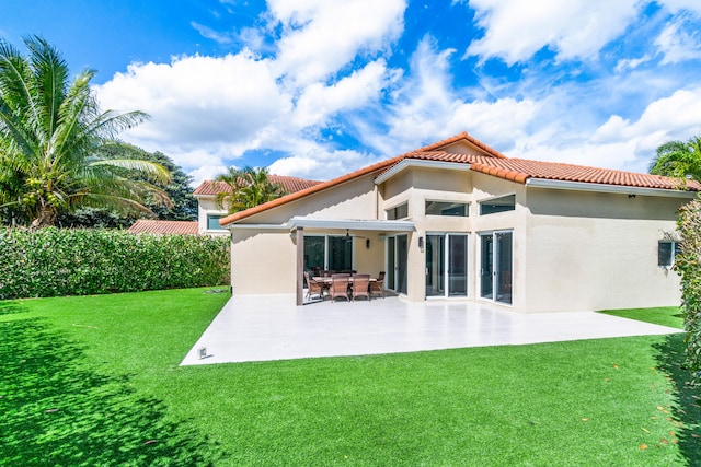 rear view of house featuring a yard and a patio area