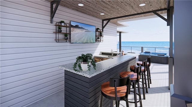 exterior space featuring a water view, light stone counters, and wooden ceiling