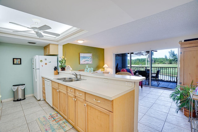 kitchen featuring ceiling fan, light tile flooring, sink, dishwasher, and a raised ceiling