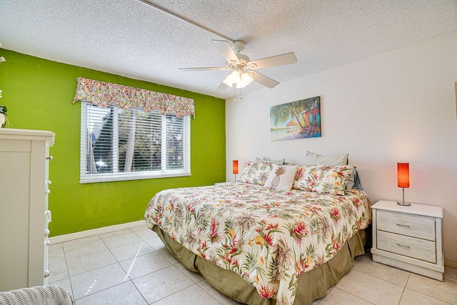 bedroom featuring light tile floors, ceiling fan, and a textured ceiling