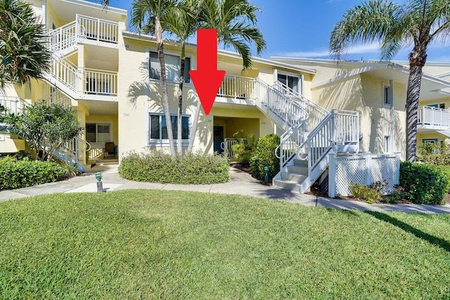 exterior space featuring a balcony and a front yard