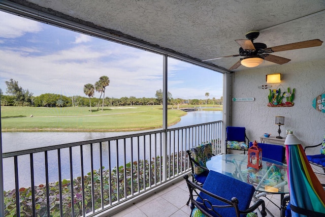 balcony featuring a water view and ceiling fan