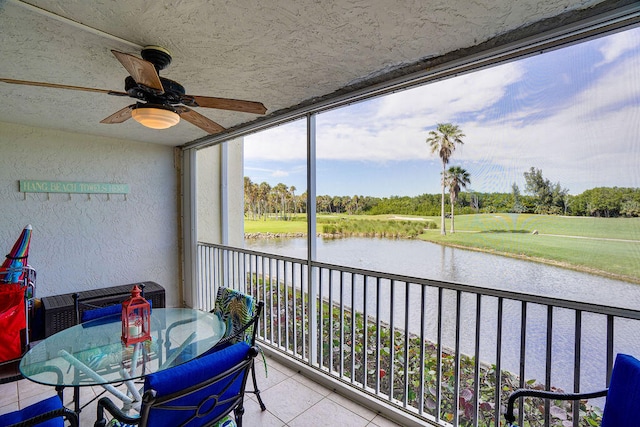 sunroom with a water view and ceiling fan