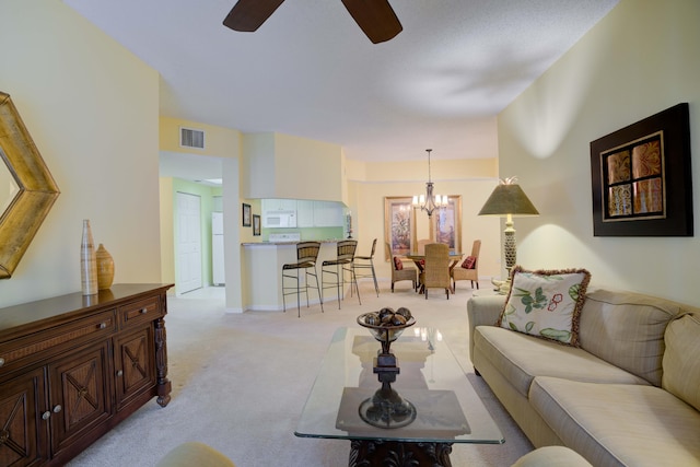 carpeted living room with ceiling fan with notable chandelier