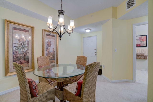 carpeted dining area with a chandelier