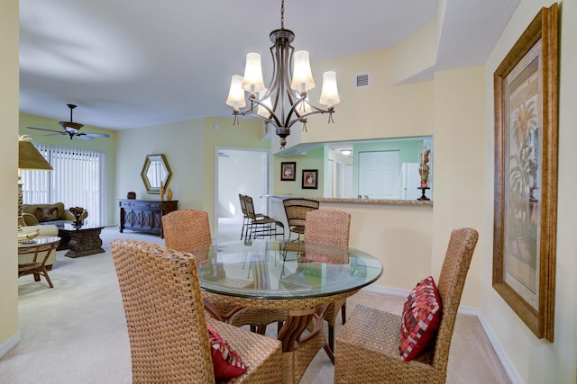 dining area with light carpet and ceiling fan with notable chandelier