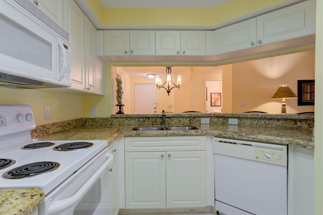 kitchen featuring white cabinetry, decorative light fixtures, white appliances, an inviting chandelier, and sink