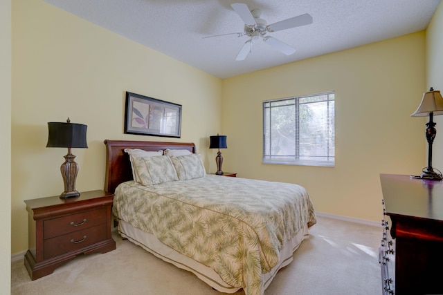 carpeted bedroom featuring a textured ceiling and ceiling fan