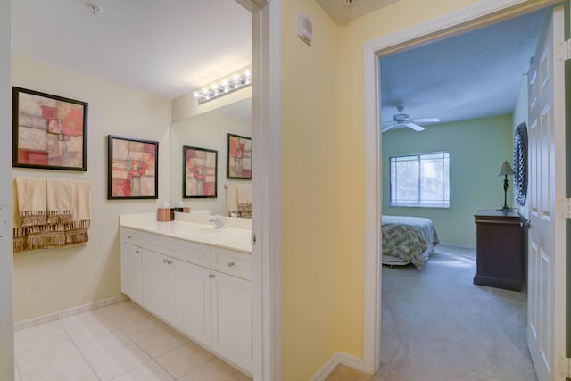 bathroom featuring ceiling fan, a textured ceiling, tile floors, and vanity with extensive cabinet space