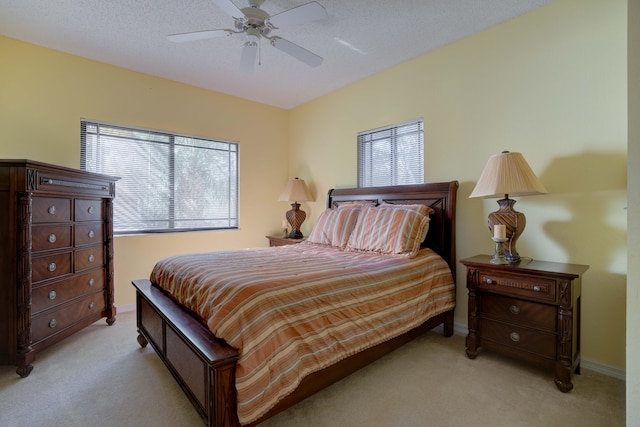 carpeted bedroom featuring a textured ceiling and ceiling fan