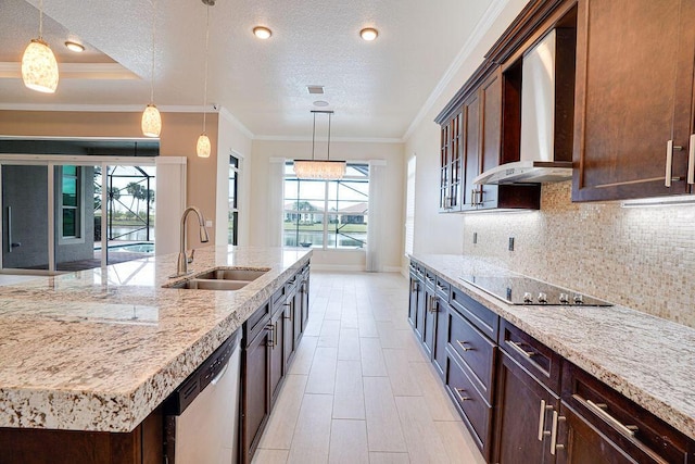 kitchen featuring black electric cooktop, sink, wall chimney exhaust hood, and decorative light fixtures